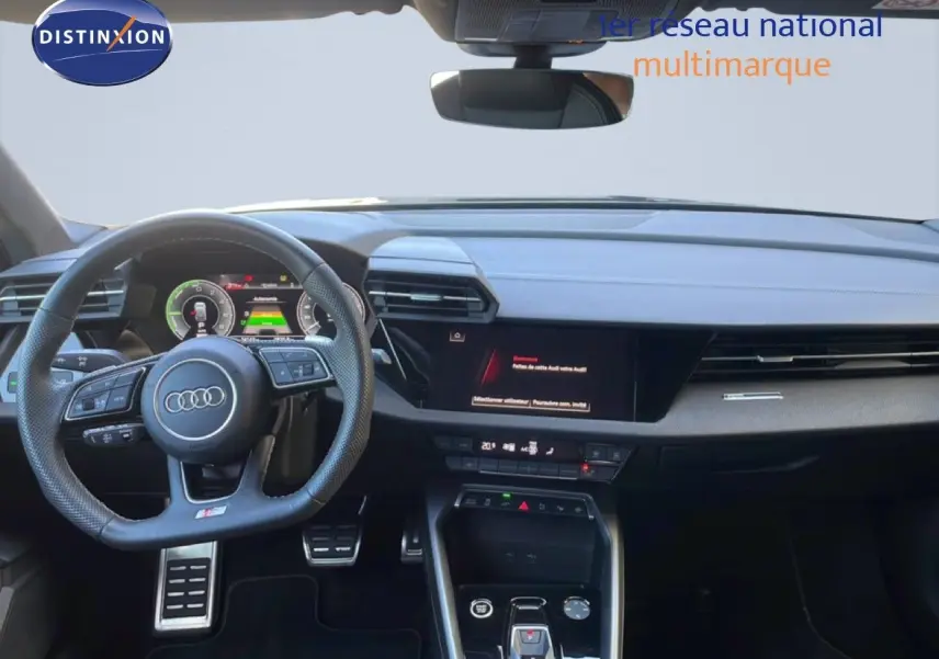 Vue intérieure de l'Audi A3 Sportback 2025 noire, tableau de bord moderne avec volant multifonction et écran digital.