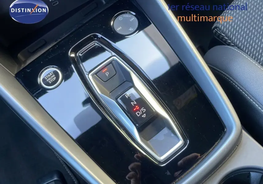 Gros plan sur la console centrale noire brillante de l'Audi A3 Sportback 40 TFSIe avec levier de vitesses automatique et bouton start/stop.