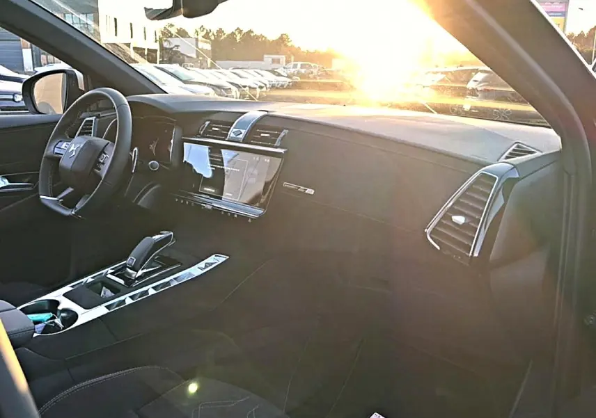 Intérieur avant droit du DS7 noir 2026, tableau de bord moderne avec écran tactile et volant cuir.