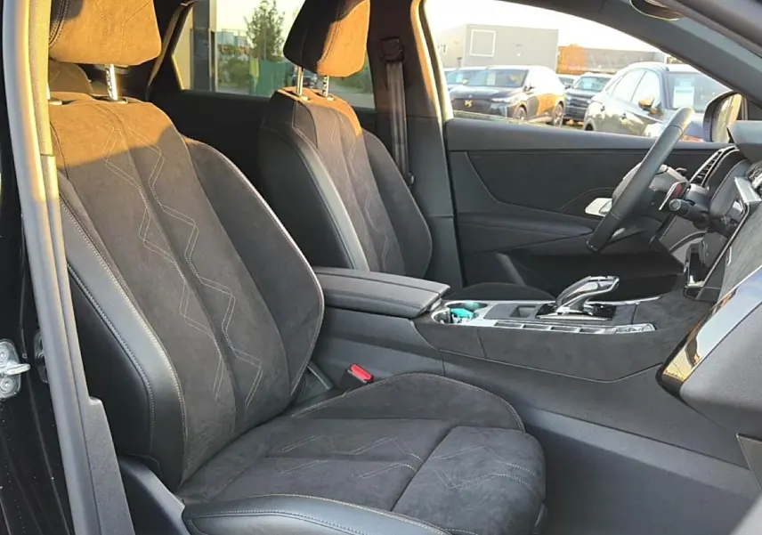 Vue intérieure côté conducteur du DS7 1.5 BlueHDi noir, sièges en alcantara avec surpiqûres et console centrale élégante.