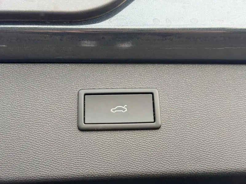 Bouton d'ouverture électrique du coffre sur une CUPRA Formentor 1.5 eTSI Hybrid 2025, détail intérieur en gris mat.