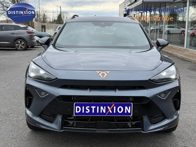 Vue frontale d'une CUPRA Formentor 1.5 eTSI Hybrid 2025 en gris magnétique mat avec logo cuivré distinctif sur le capot.