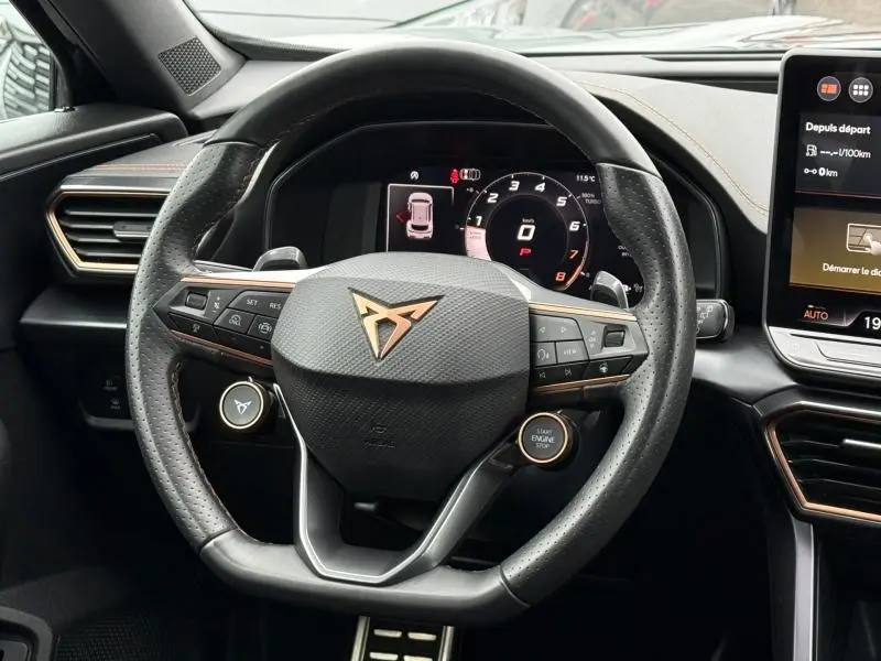 Vue rapprochée du volant multifonction du CUPRA Formentor 1.5 eTSI Hybrid 2025 avec logo cuivré et tableau de bord numérique.