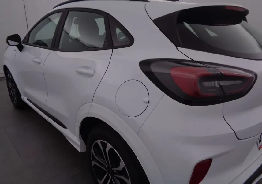 Vue 3/4 arrière droite d'un Ford Puma blanc 2022 finition ST-LINE avec feux arrière LED et jantes bi-ton.