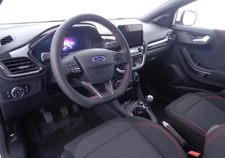 Intérieur avant droit du Ford Puma 2022, volant cuir noir avec surpiqûres rouges et console centrale moderne.