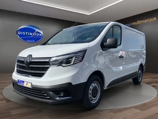 Fourgon Renault Trafic blanc en 3/4 avant droit, avec calandre noire et phares LED, présenté en showroom.