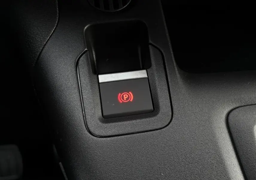 Gros plan sur le bouton de frein de stationnement électrique rouge dans l'habitacle noir du Citroën Berlingo Van XL 2025
