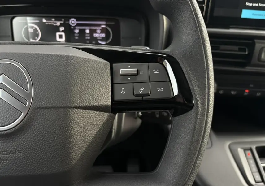 Gros plan sur le volant multifonctions côté droit du Citroën Berlingo Van XL 2025 avec commandes audio et téléphone.