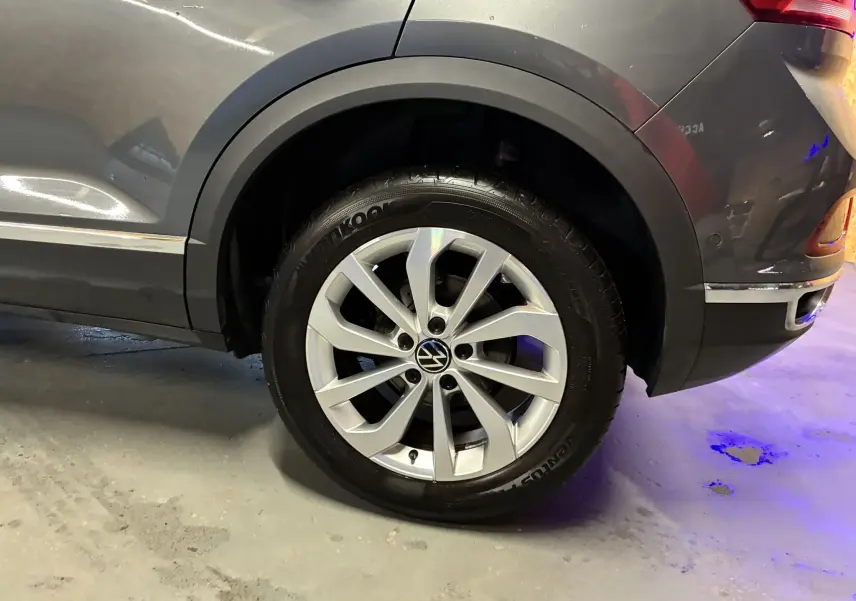 Gros plan sur la roue arrière droite d’un Volkswagen T-Roc gris 2023, mettant en valeur la jante alliage et le pneu Hankook.