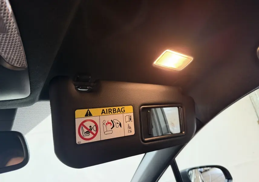 Détail du pare-soleil côté conducteur avec miroir et avertissement airbag dans un Toyota C-HR gris foncé.