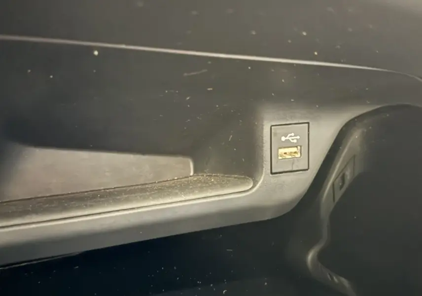 Vue rapprochée du port USB intégré dans la console centrale noire du Toyota C-HR gris foncé 2022.