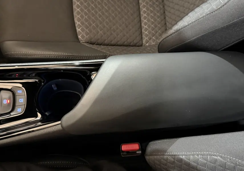 Détail de l'accoudoir central noir et du siège gris à motifs du Toyota C-HR 1.8 Hybride 122 Edition 2022.