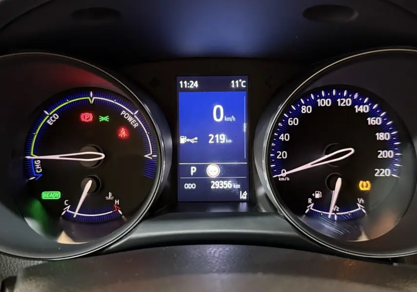 Tableau de bord numérique du Toyota C-HR gris foncé, affichage central 8 pouces et compteurs analogiques éclairés bleu.