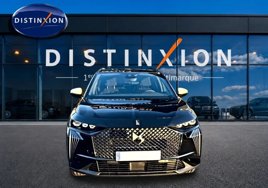 Vue avant du DS7 noir 2026 avec calandre distinctive et phares LED, devant une vitrine de concession Distinxion.