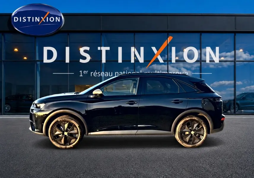Vue de profil côté gauche d'un DS7 noir 2026 avec jantes noires et rétroviseurs chromés devant un showroom Distinxion.