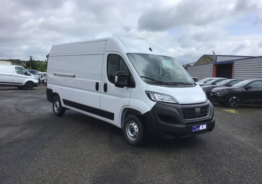 Fourgon blanc FIAT Ducato 35 LH2 vu en 3/4 avant droit sur un parking sous ciel nuageux.