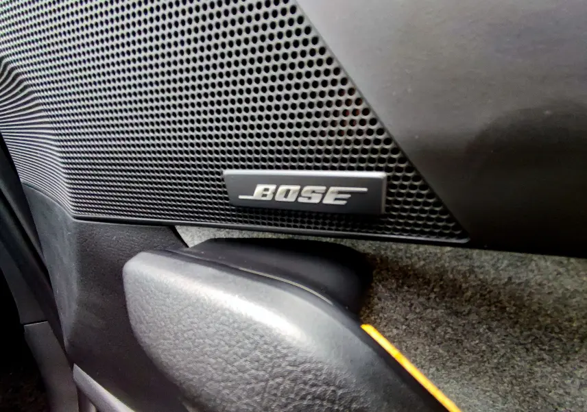 Gros plan sur l'enceinte Bose intégrée à la porte intérieure du Mazda MX-30 gris foncé 2023.