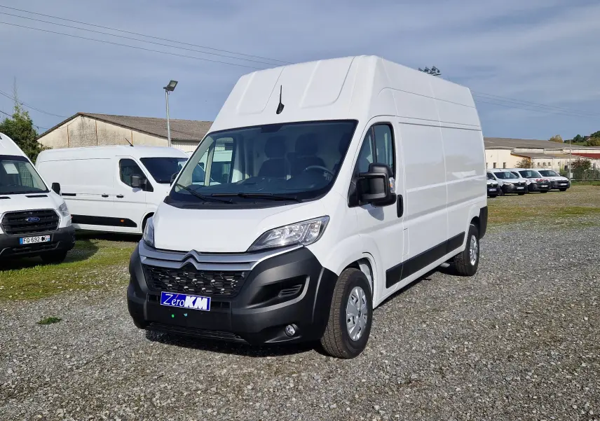 Vue 3/4 avant d’un Citroën Jumper blanc L3H3 2023 avec calandre noire et plaque Zero KM sur un parking.