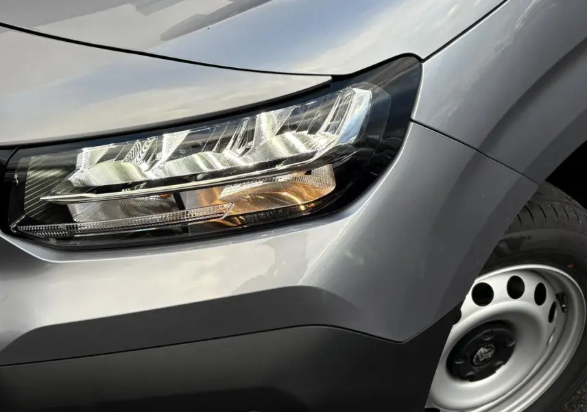 Gros plan sur le phare avant droit et la jante acier grise du Citroën Berlingo Van XL gris Artense 2025