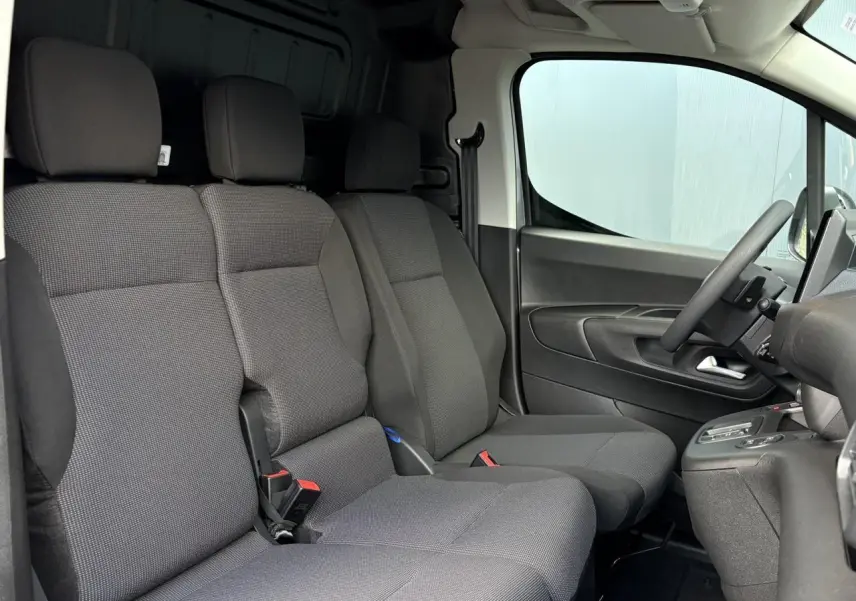 Vue intérieure côté conducteur du Citroën Berlingo Van XL 2025 avec sièges tissu gris et volant multifonctions.