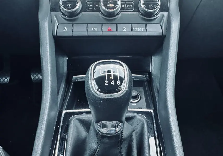 Gros plan sur le levier de vitesse manuel noir du Skoda Karoq 2024, entouré de la console centrale et commandes de climatisation.