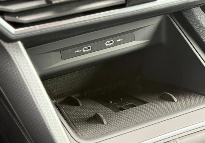 Gros plan sur la connectivité USB-C et le rangement avant du SEAT Leon noir Minuit, intérieur moderne et fonctionnel.