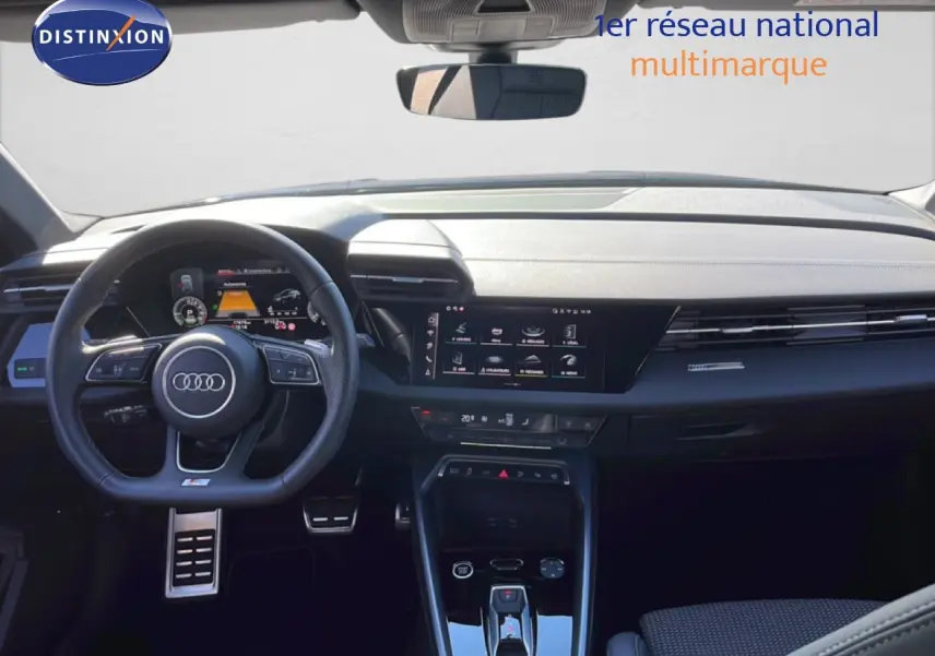 Vue intérieure frontale de l'Audi A3 Sportback 2025, tableau de bord noir avec écran tactile et volant multifonction.