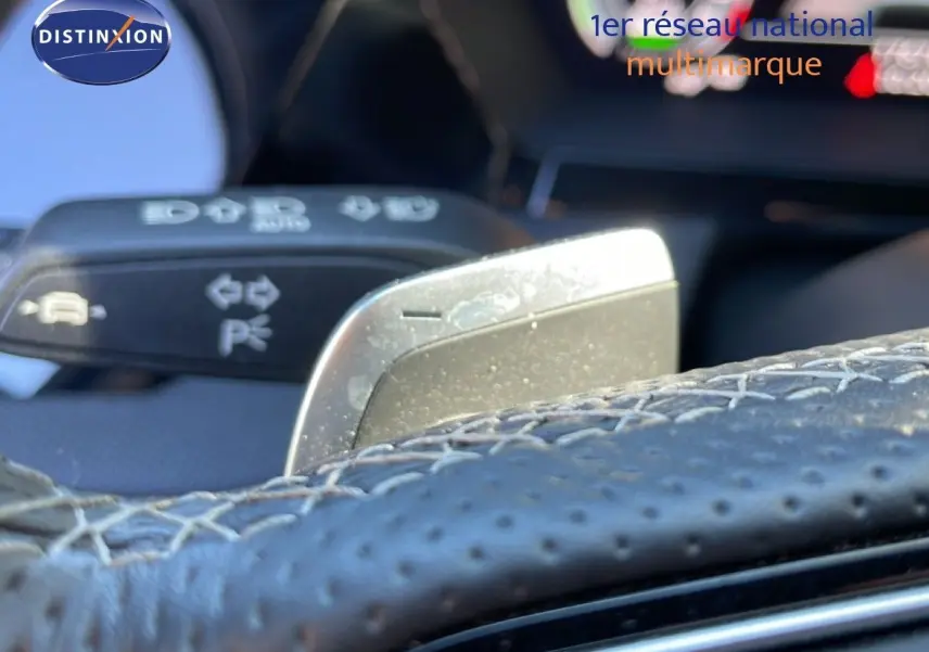 Gros plan sur la palette de changement de vitesse derrière le volant en cuir perforé de l'Audi A3 Sportback 2025.