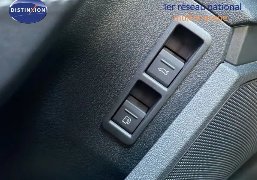 Détail des boutons d'ouverture du coffre et de la trappe à carburant sur la porte intérieure d'une Audi A3 Sportback bleu Navarre.