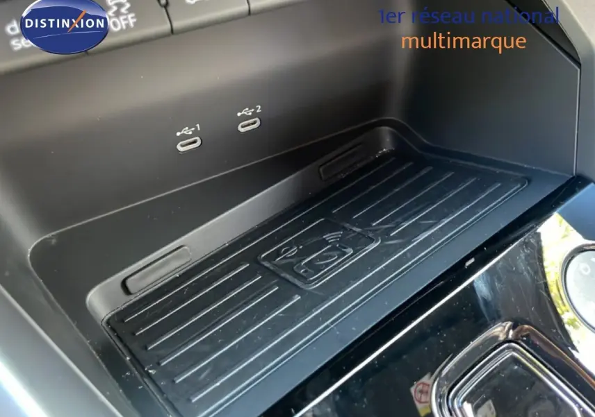 Gros plan sur la zone de recharge sans fil et ports USB-C de l’Audi A3 Sportback bleu Navarre 2025, intérieur noir.
