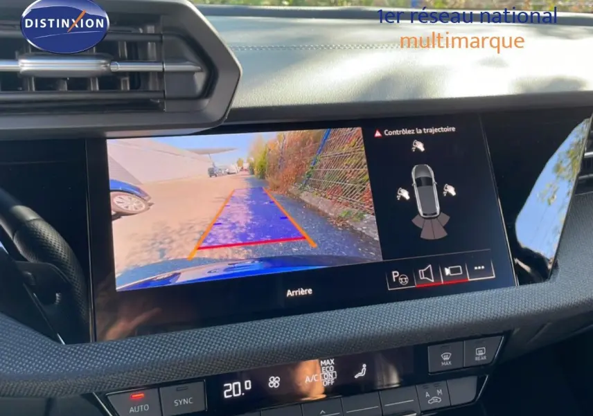 Vue intérieure du tableau de bord de l’Audi A3 Sportback bleu Navarre, écran affichant la caméra de recul et les commandes climatiques.