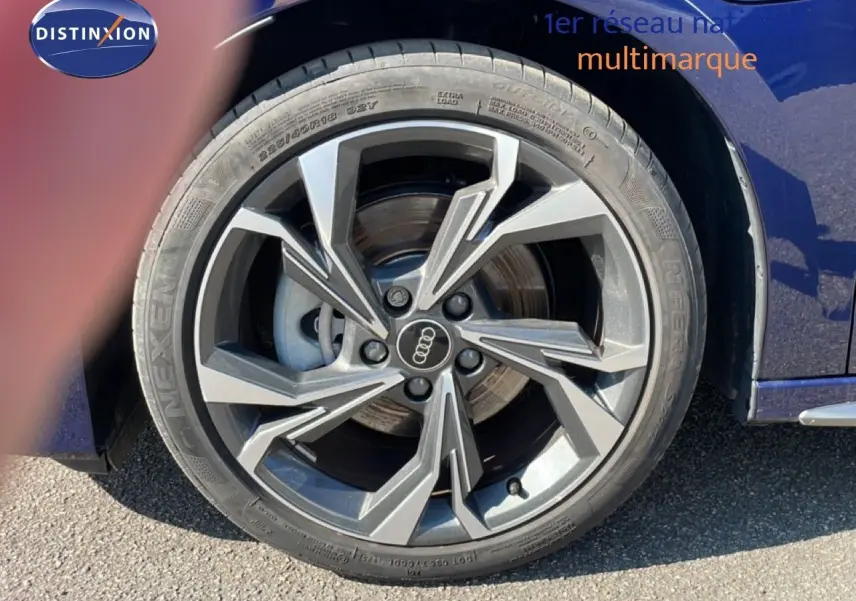 Gros plan sur la roue avant droite d'une Audi A3 Sportback bleu Navarre métal avec jante alliage au design moderne.
