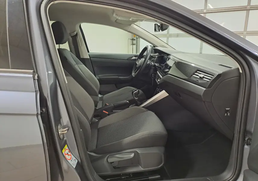 Vue intérieure côté conducteur de la Volkswagen Polo gris cendre 2025, mettant en valeur les sièges et le tableau de bord moderne.