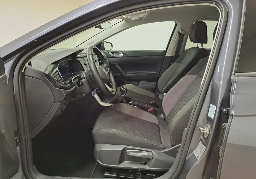 Vue intérieure côté conducteur de la Volkswagen Polo gris cendre 2025, sièges tissu et tableau de bord moderne.