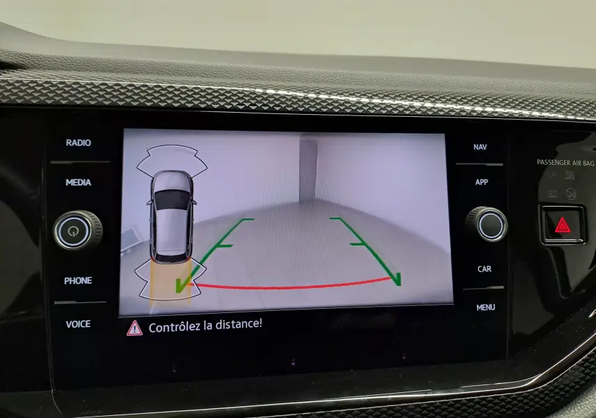 Écran intérieur affichant la caméra de recul et l’aide au stationnement du Volkswagen Polo gris cendre, vue de dessus du véhicule.