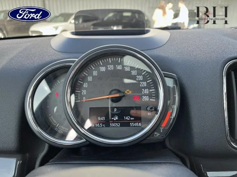 Vue rapprochée du compteur central et indicateur de charge du tableau de bord d'une MINI Countryman Cooper SE hybride.