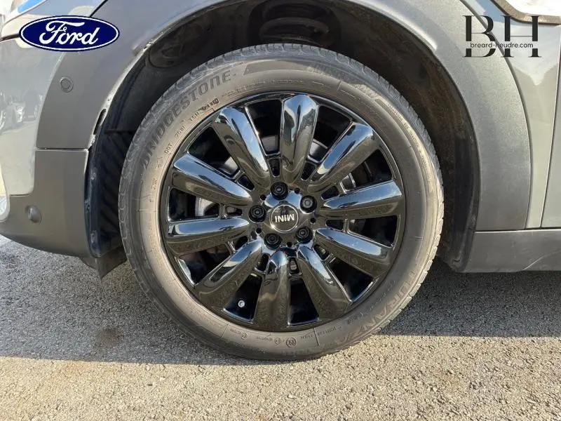 Gros plan sur la jante noire brillante 18 pouces Black Pin Spoke côté avant droit d'une MINI Countryman Moonwalk Grey hybride rechargeable.