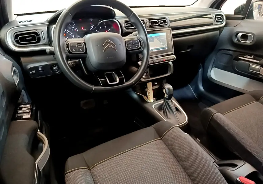 Intérieur avant de la Citroën C3 gris clair 2019, vue côté conducteur sur le tableau de bord et volant multifonctions cuir.
