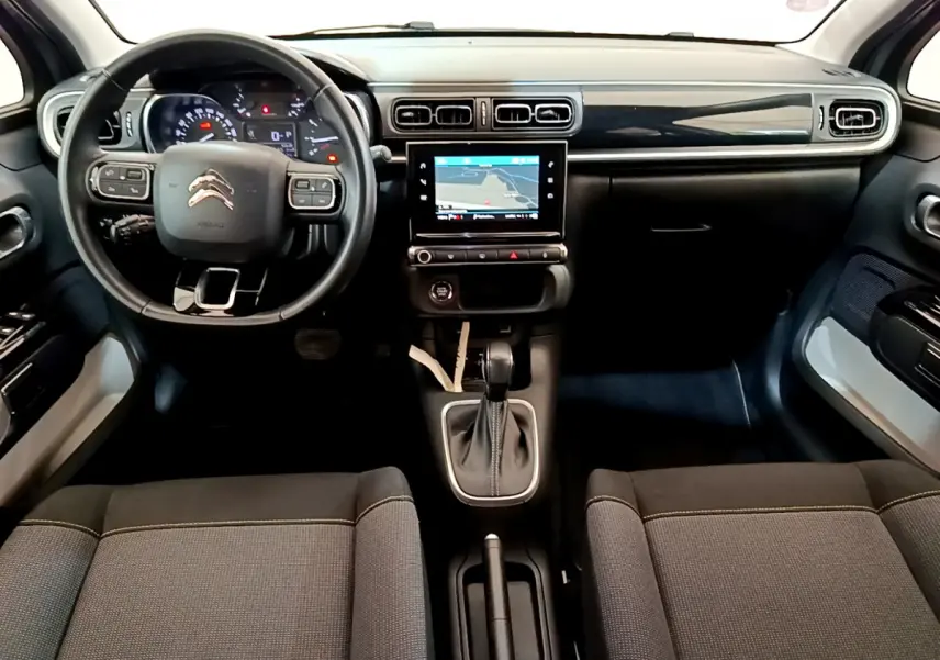 Vue intérieure avant du Citroën C3 gris clair 2019 avec tableau de bord noir et écran tactile central.