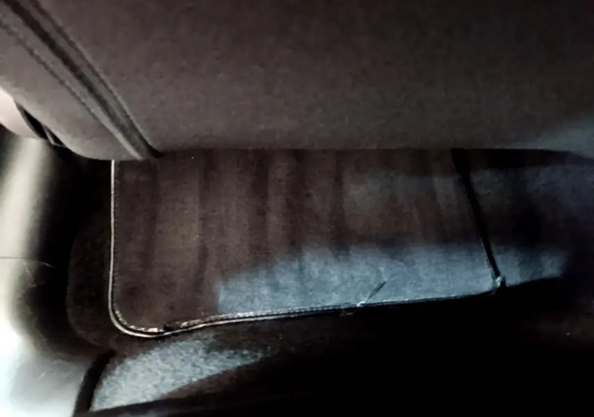 Tapis de sol noir sous le siège avant droit d'une Citroën C3 gris clair, vue rapprochée intérieure