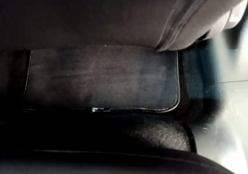 Tapis de sol noir sous le siège arrière côté gauche d'une Citroën C3 gris clair 2019 vue en intérieur.