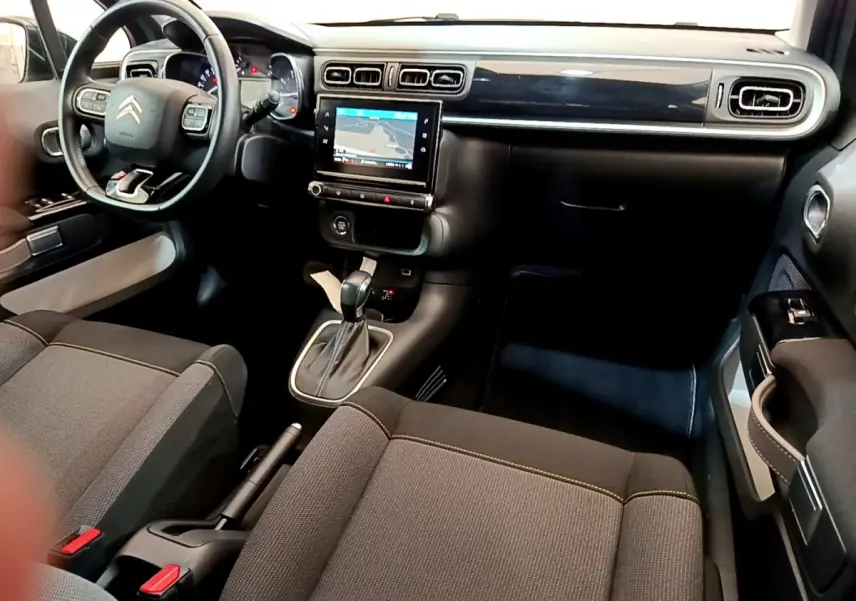 Intérieur avant du Citroën C3 gris clair 2019, avec tableau de bord noir, écran tactile central et volant cuir multifonctions.