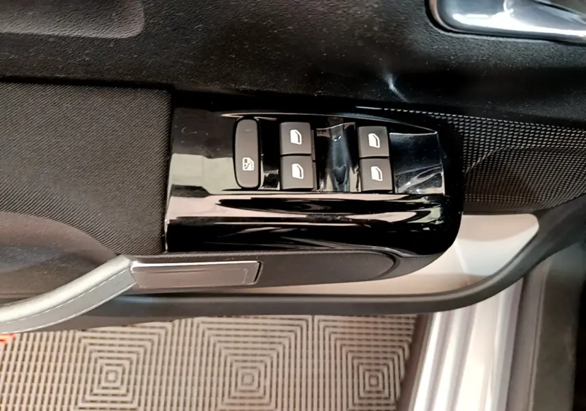 Commande des vitres électriques sur la porte côté conducteur d'une Citroën C3 gris clair, vue intérieure rapprochée.