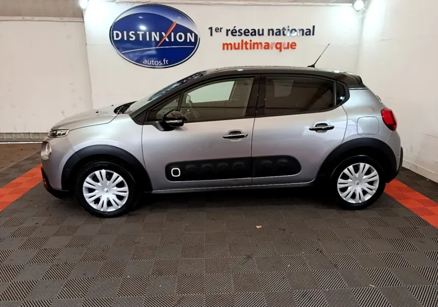 Profil côté gauche d'une Citroën C3 gris clair 2019 avec protections latérales noires et jantes acier blanches.