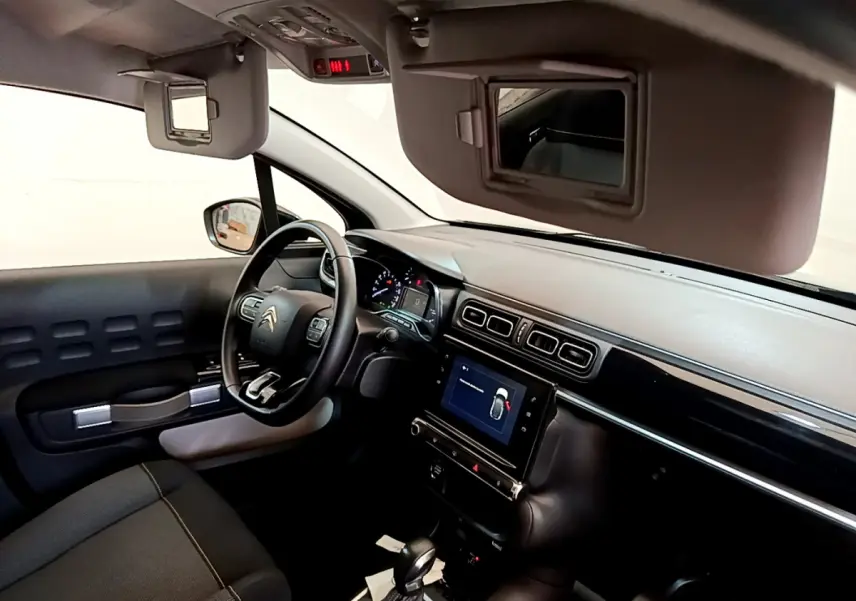 Intérieur de la Citroën C3 2019, vue côté conducteur, tableau de bord noir avec écran tactile central et volant cuir multi-fonctions.