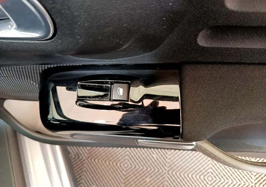 Gros plan sur la commande de lève-vitre côté conducteur d'une Citroën C3 2019, intérieur noir et gris.