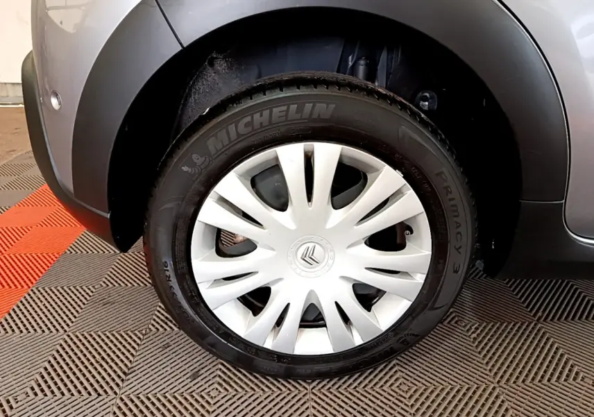 Gros plan sur la roue arrière droite gris clair d'une Citroën C3 2019 avec jante acier et enjoliveur blanc.