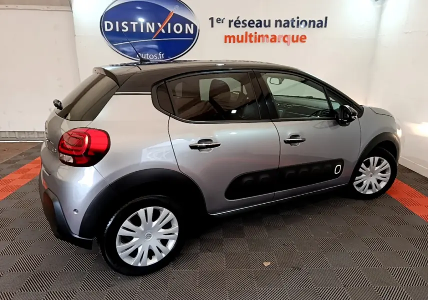 Citroën C3 gris clair vue de profil côté droit, avec protections noires caractéristiques sur les portières.