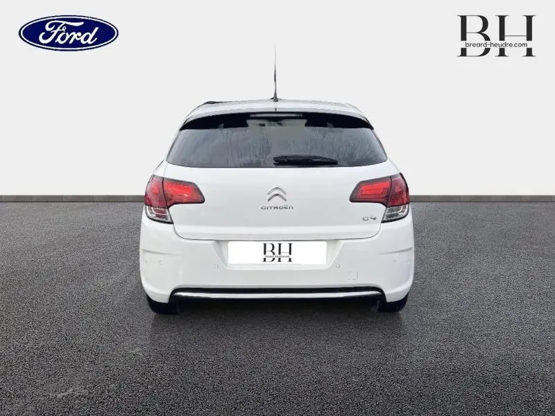Vue arrière d'une Citroën C4 blanche de 2017 avec lunette arrière surteintée et feux rouges distinctifs.
