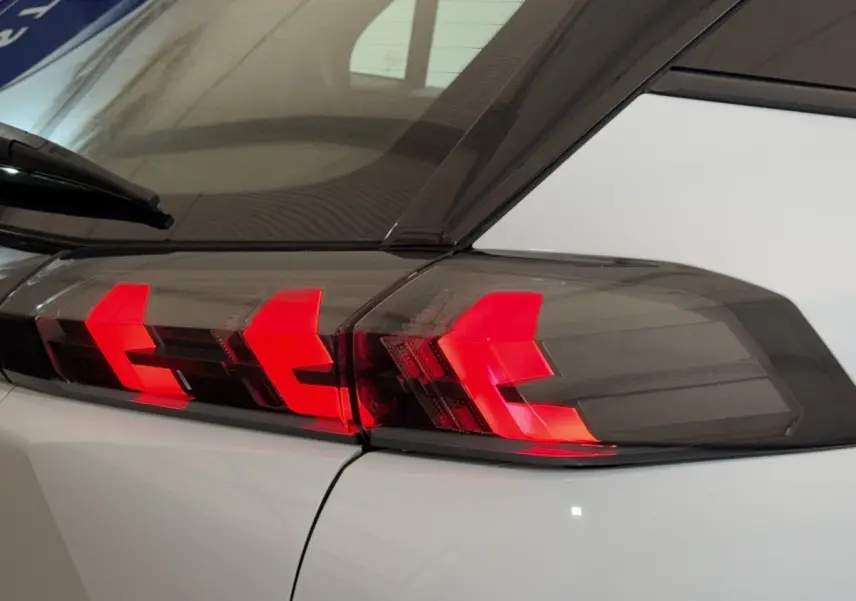 Gros plan sur le feu arrière droit rouge et noir du Peugeot 2008 blanc, vue arrière latérale.